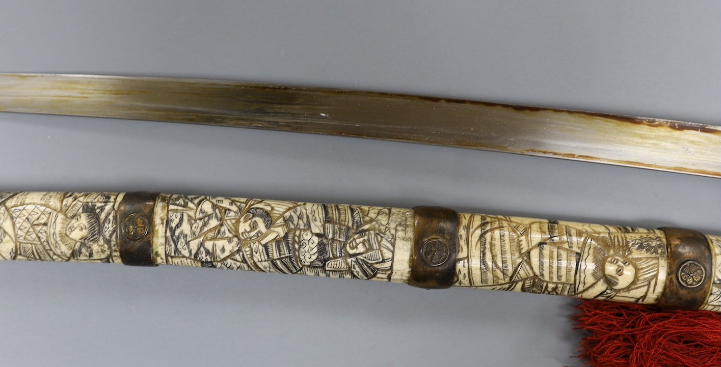 A late 19th century Japanese wakizashi sword, the blade 47.5cm, with sectional stag's horn scabbard and hilt carved with warriors and other figures, gilt metal mounted